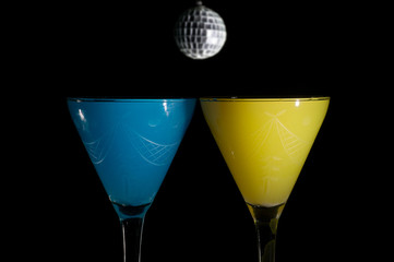 two drinks on a party night on black background