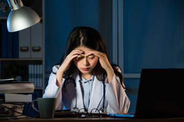 sleepy doctor holding hand over her head