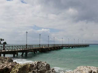 Obraz premium Wooden pier, Barbados View of the wooden pier fronting the Caribbean Ocean, Barbados on a bleak day