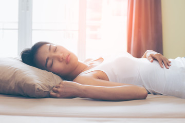Obraz na płótnie Canvas Asian cute woman deep sleep on bed in the morning, model is a asian beauty