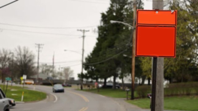 Blank generic orange construction sign in daytime near main road