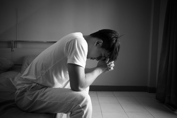 Asian man with sad mood in the room, sadness portrait concept, black and white tone.