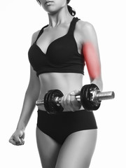 beautiful sporty muscular woman working out with dumbbell pain area