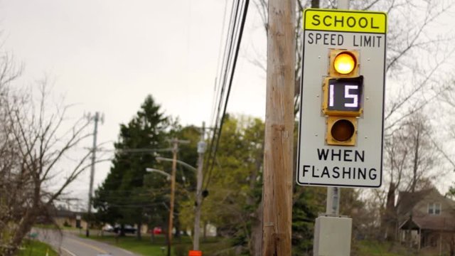 A school speed limit when flashing - fifteen miles an hour sign - close up angle