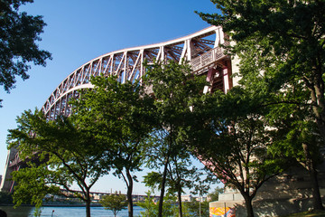 Hell Gate Bridge over the river and trees with blue sky at Astoria park, New York