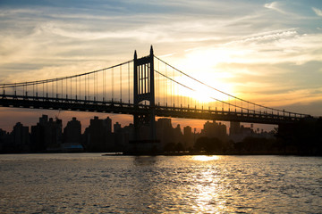 Triborough bridge and city with sunset in silhouette, New York