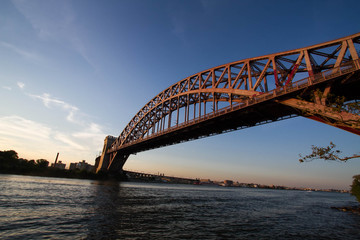 Fototapeta na wymiar The Hell Gate Bridge over the river with sunset sky, New York
