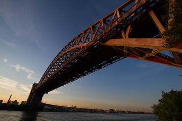The Hell Gate Bridge over the river with sunset sky, New York