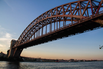 The Hell Gate Bridge over the river with sunset sky, New York