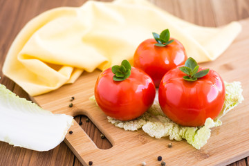 Помидоры и листья пекинской капусты на разделочной доске