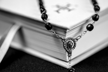 White prayer book and black rosary