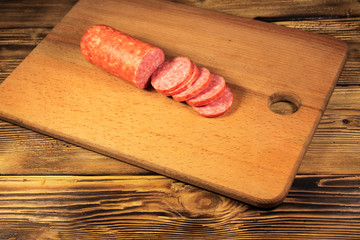 Sausage sliced on cutting board on wooden table