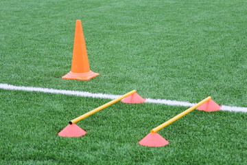 Chips and cone for football training. Sports background with markings on an artificial lawn on a soccer field.