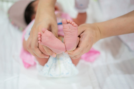 Newborn baby feet in mother's hands.Baby's foot in femel doctor or nurse hands closeup,copy space
