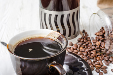 coffee cup and coffee beans on white wooden table
