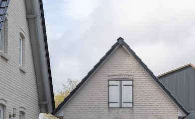 Giebel mit weißem Mauerwerk und Fensterläden