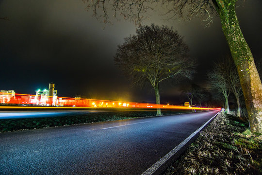 Stra&szlig;en Lightpainting bei Nacht mit Baum