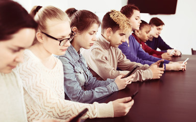 Fellow students playing with their smartphones