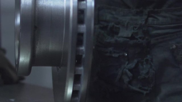 Factory worker inspecting a brake disc. 2K HD SLO MO