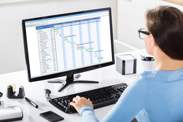 Businesswoman Working On Gantt Chart On Office Desk