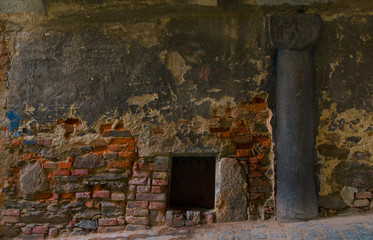 Stones column from 14 century with old stones and bricks wall