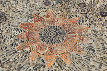Patterned floor with pattern from pebbles bricks and gears