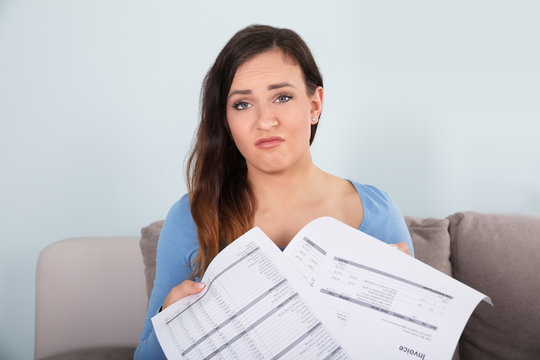 Confused Woman With Documents In Hands