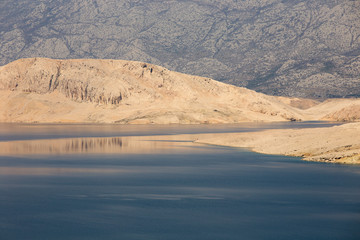 Desert landscape with blue water sea on island Pag, Croatia - beautiful sea water background