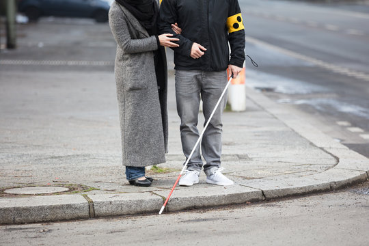 Woman With A Blind Man On Street