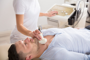 Obraz na płótnie Canvas Young Man Getting Ultrasound Of A Thyroid