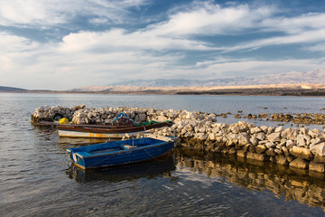 Wooden rowboat - Old fishing boats in old stone sea harbour on island Pag, Croatia