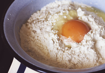 Broken raw egg in flour