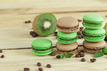 Green and brown french macarons with kiwi, coffee beans and mints decorations