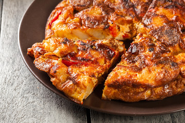 Tortilla de patatas. Spanish omelette with sausage chorizo, potatoes, paprika and egg, accompanied by olive oil