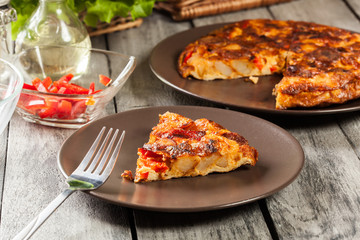 Tortilla de patatas. Spanish omelette with sausage chorizo, potatoes, paprika and egg, accompanied by olive oil