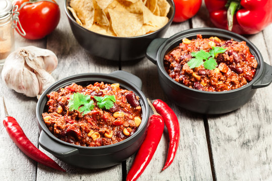 Bowls of hot chili con carne with ground beef, beans, tomatoes and corn