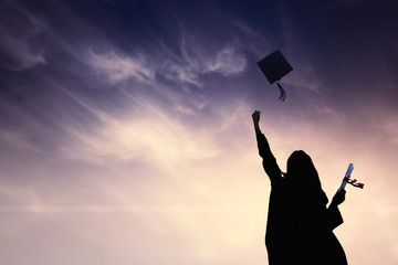 Graduate students tossing up hats over blue sky