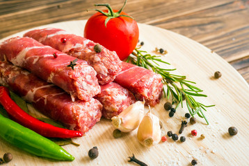 Raw cevapcici dish of mixed meats, the food of the Balkans. Minced meat and bacon.