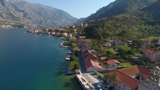 Aerial view of the Prcanj city embankment with ancient houses and church. 
Adriatic sea, Kotor bay, Montenegro.