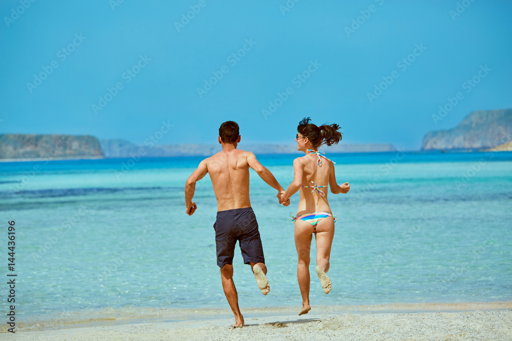 Wall mural young happy couple running on the beach. Balos beach, Crete, Greece.