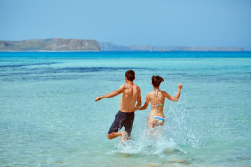 young happy couple running on the beach. Balos beach, Crete, Greece.