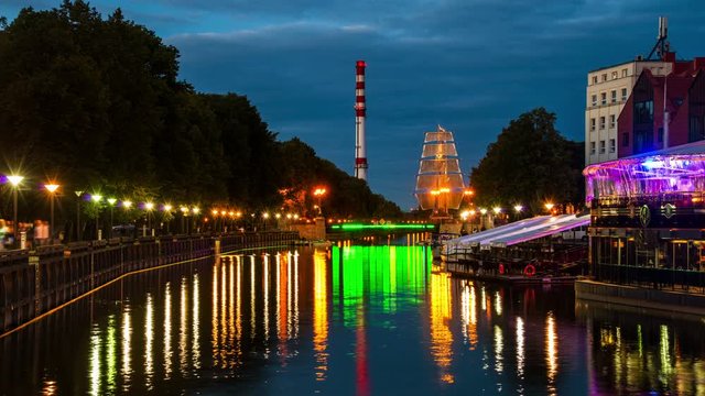 Klaipeda, Lithuania. Night view of the city center with river cafe and illuminated ship in Klaipeda, Lithuania. Time-lapse at sunset