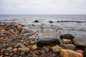 Fototapeta na wymiar Stones on the shore of stormy waving Ladoga lake. Priozersk, Russia