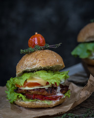 Burgers with dried tomatoes on a wooden table on a blue background