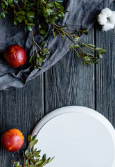 Food frame with blood oranges with green leaves on a black wooden background
