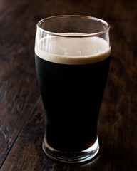 Dark Beer on wooden surface. Close up view.