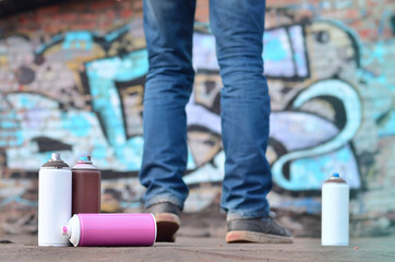A photography of a certain number of paint cans against the graffiti background