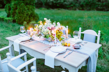 Table setting with dishes, cutler, candles and floristic. European wedding