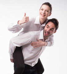 Young happy couple showing presentation pointing on placard over gray background