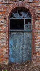 Picture of old, destroyed door with broken window.